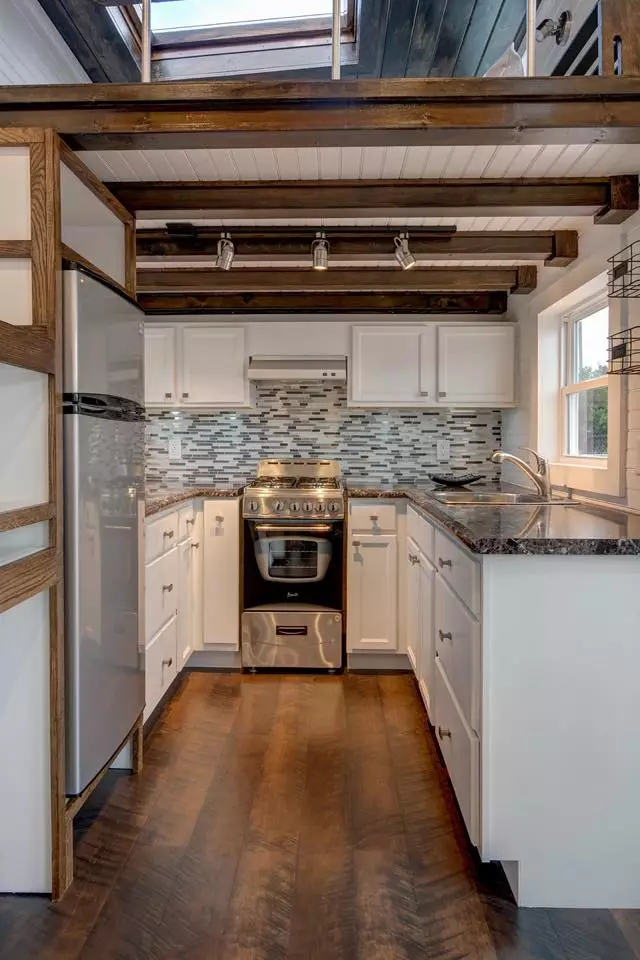 The kitchen contains the usual amenities, such as a four-burner oven, sink, fridge, etc