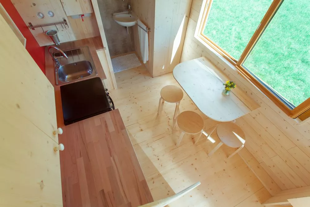 La Tête dans les étoiles' kitchen includes a sink, oven with propane-powered stove, fridge, and some cupboard space