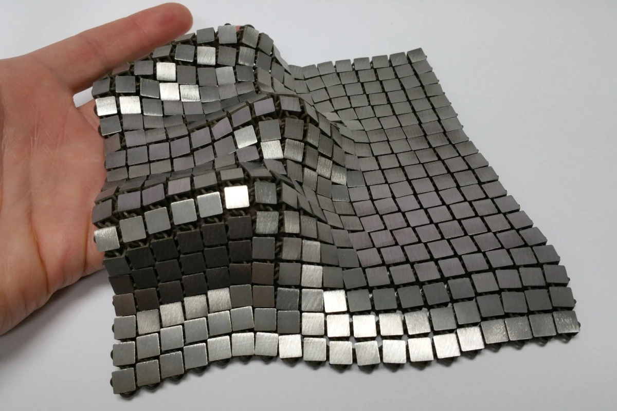 The metallic "space fabric" that was created using 3-D printing techniques that allow different functionality to be integrated into each side of the material