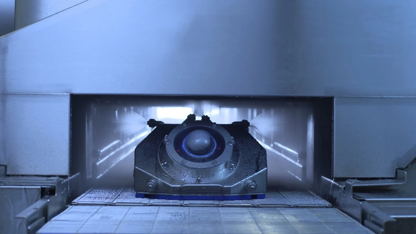 One model of the MCD robot is loaded onto an existing conveyor belt, where it rides through the production line, cleaning the equipment from the inside