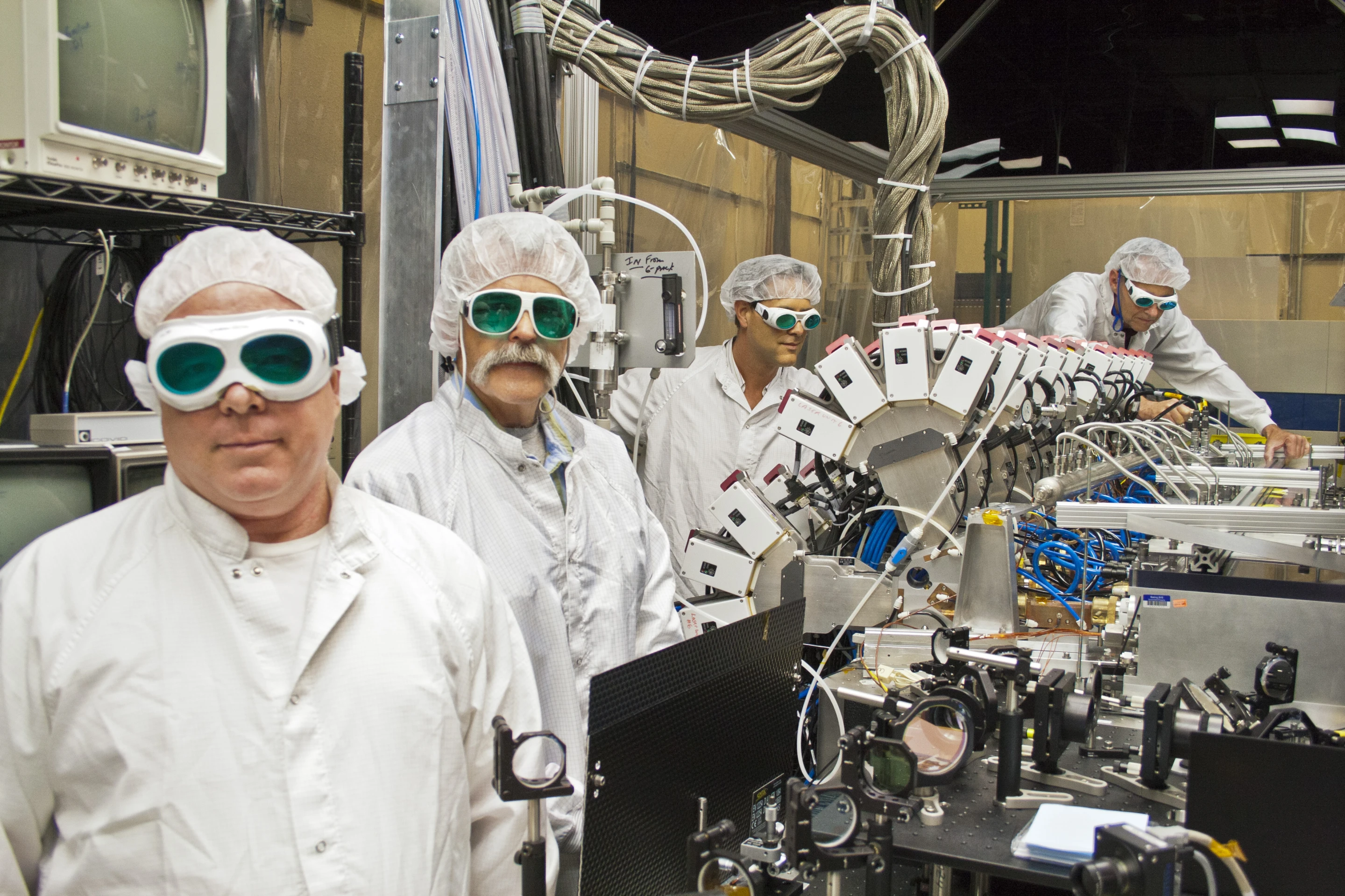 Boeing Thin Disk Laser engineers and the laser's main optical bench (Photo: Boeing)