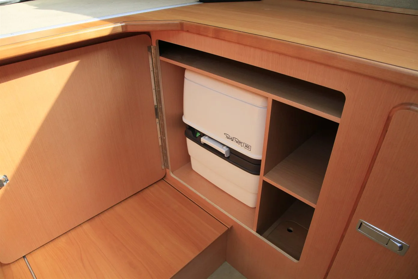 The toilet tucks away in a storage compartment