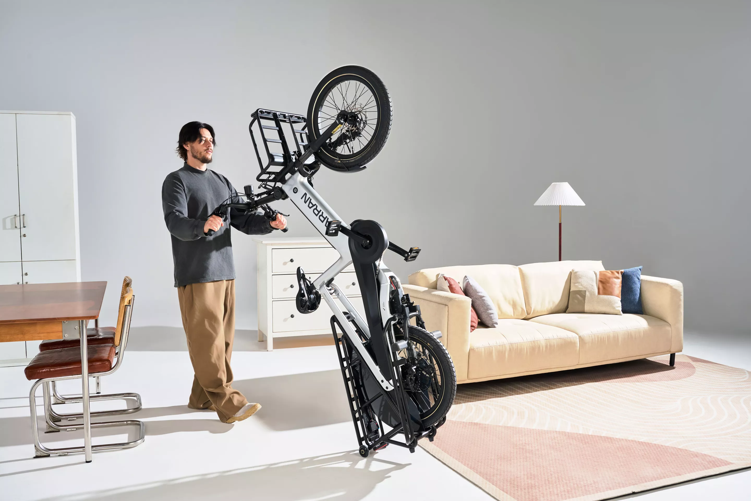 The Tarran L1 Series cargo ebike can be wheeled to its storage spot in the apartment on rack-mounted mini wheels, keeping dirty tires off the carpet