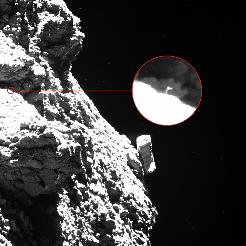 In this Rosetta image, one of the Philae lander's "feet" can be seen protruding from behind an obscuring boulder to the upper left of the shot, appearing as a thin vertical line with a broad top