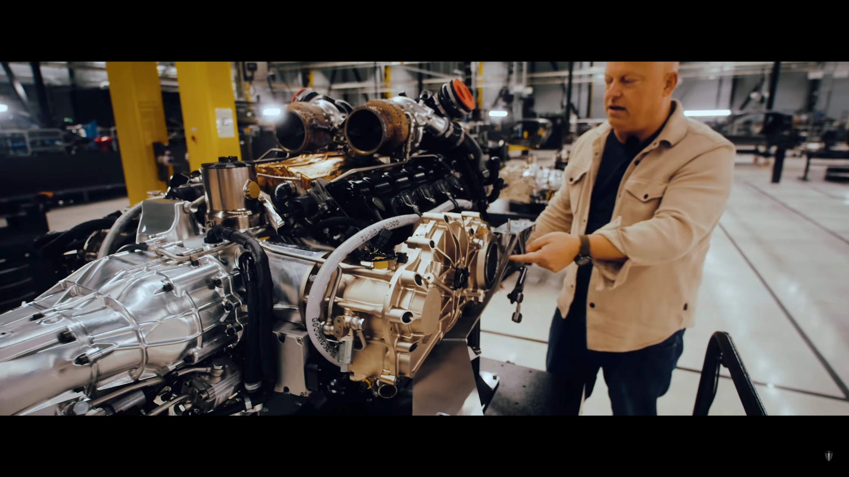 Christian von Koenigsegg points to the output flange on the Light Speed Tourbillon Transmission (LSTT), with the "Hot V8" 1,500 horsepower (1,119 kW) engine nestled within the gear-train cassettes