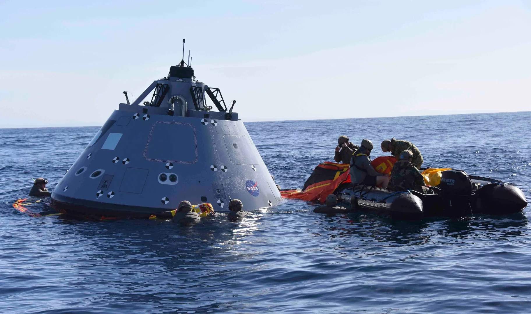 US Navy divers and the Orion test capsule
