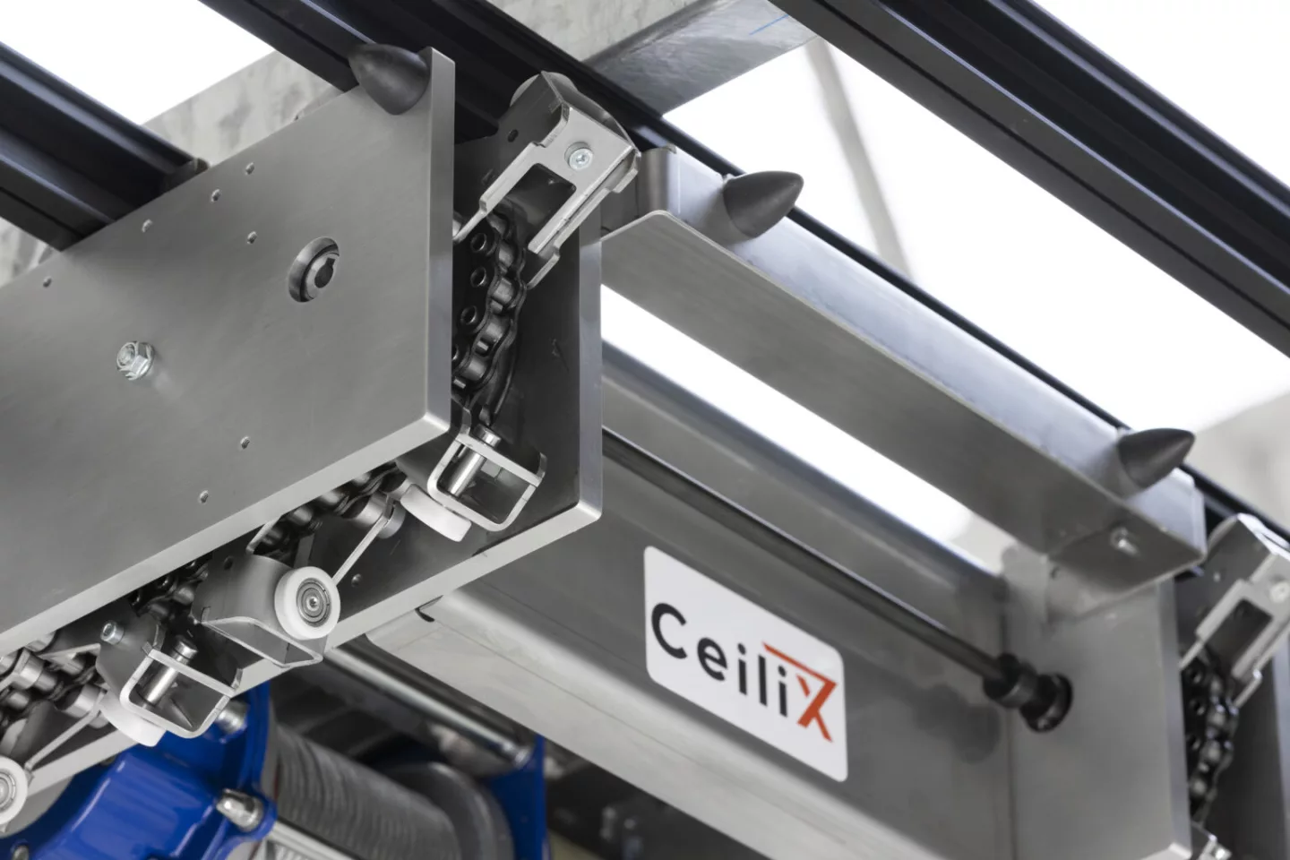 You can see CeiliX's chain drive on the Skyrunner that opens and closes the roller-equipped grippers that attach it to the track while allowing it to move in any direction
