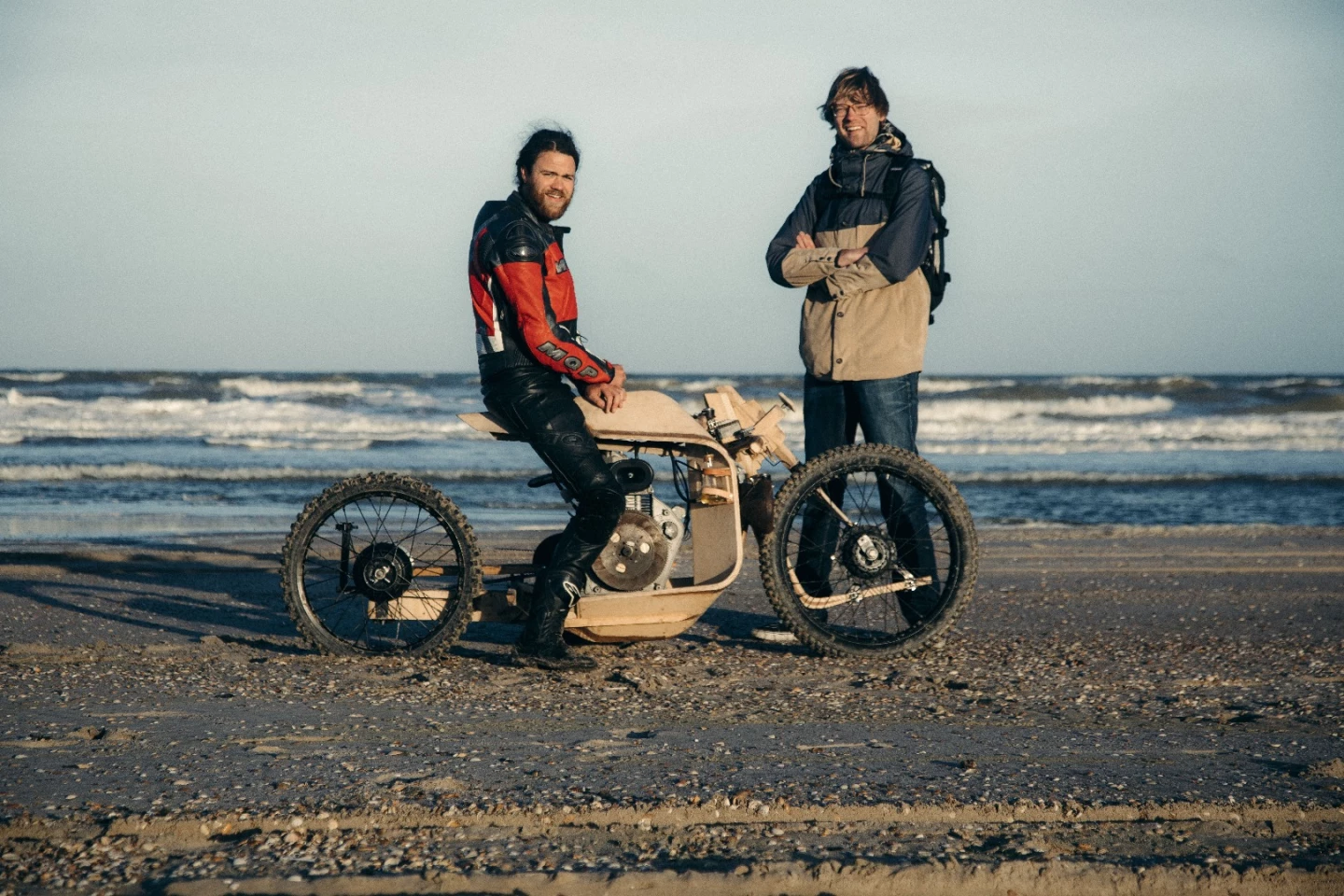 Ritsert Mans (left) and Peter Mooij (right) on the beach with the algae-fueled wooden motorcycle