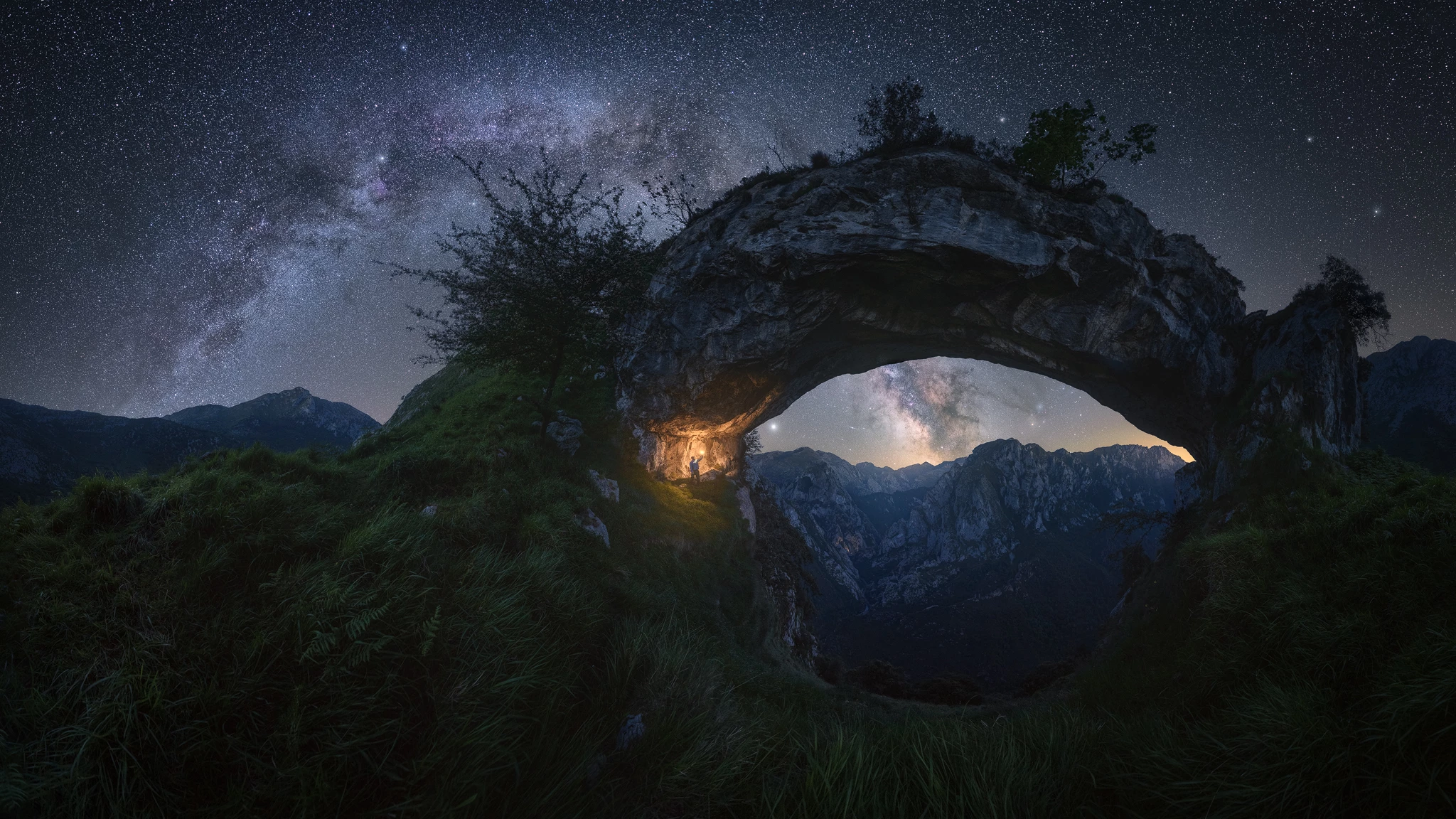 Double Arch, shot in Picos de Europa, Spain. An arch-shaped rock formation in La Hermida gorge mimics the Milky Way in the sky overhead.