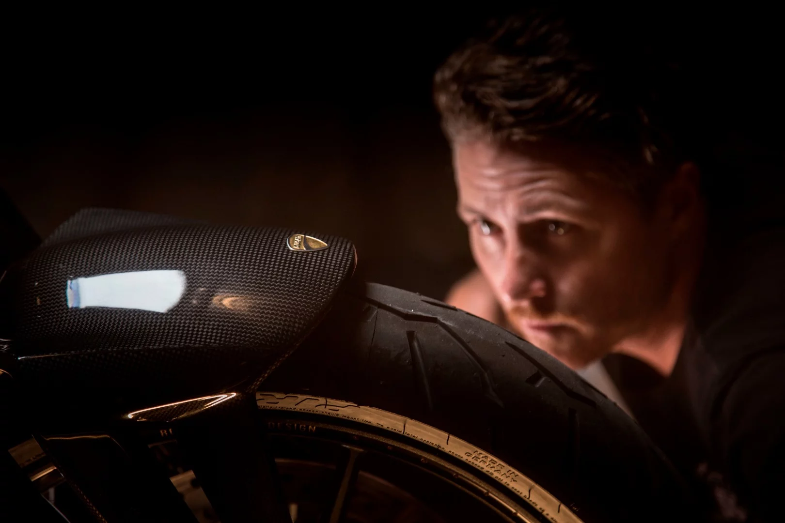 Roland Sands stares at his carbon front guard with stirring intensity