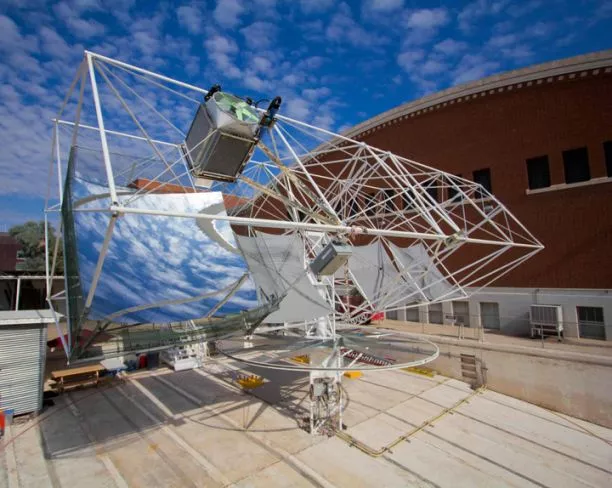 A dish-shaped mirror focuses sunlight onto a glass ball, which distributes it evenly onto an array of photovoltaic cells (Photo: Blake Coughenour/UA)