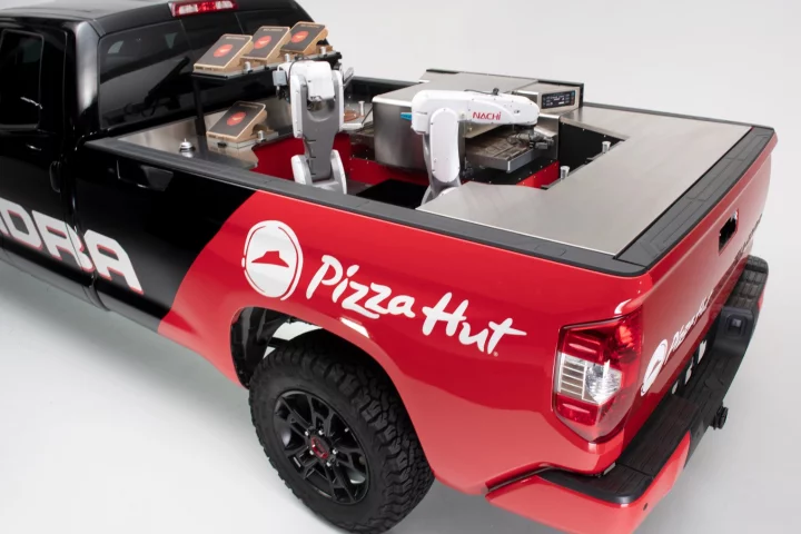 The Tundra Pie Pro's mobile pizza factory consists of two robotic arms, a refrigerator, and a high-intensity conveyor oven