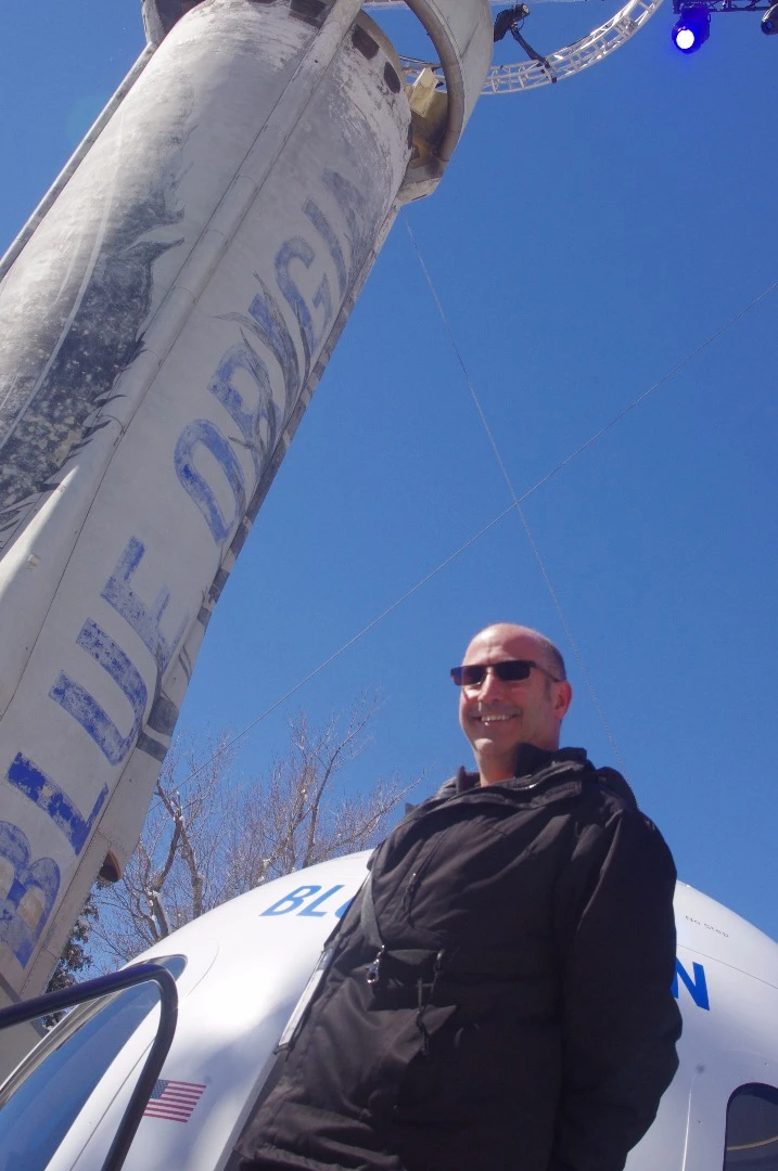 New Atlas' Michael Franco outside the Blue Origin crew capsule and New Shepard rocket