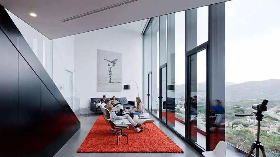 The main living space of X House, with double-height ceiling and impressive views