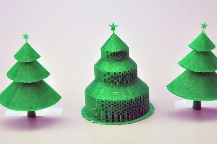 The Christmas tree in the center was 3D-printed in the traditional manner, and displays the extra material to support each branch. Beside it are the two halves of the same tree printed using the new algorithm, with no supportive material to remove (Photo: Simon Fraser University)