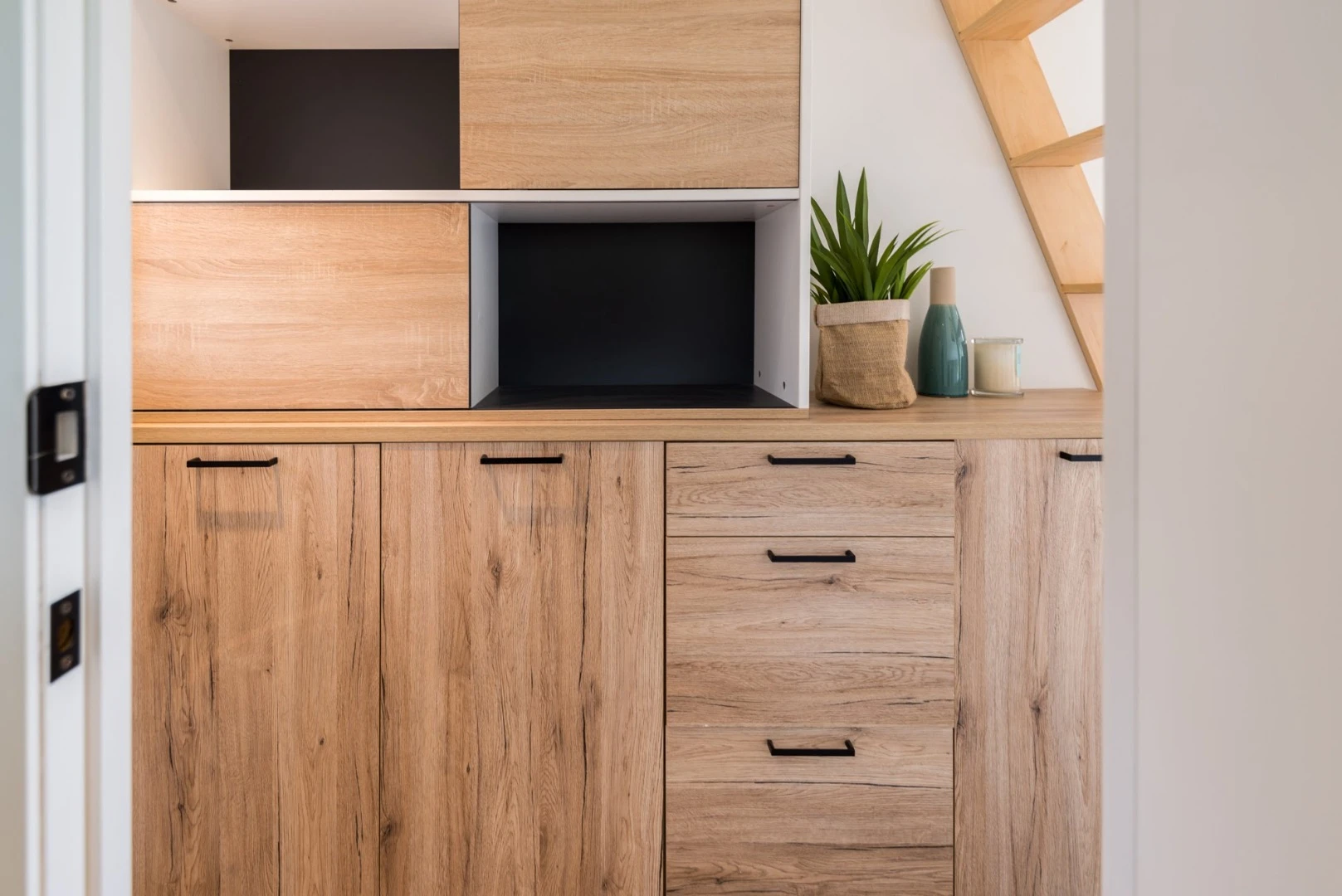 Ample storage lines the wall of the Pohutukawa tiny house