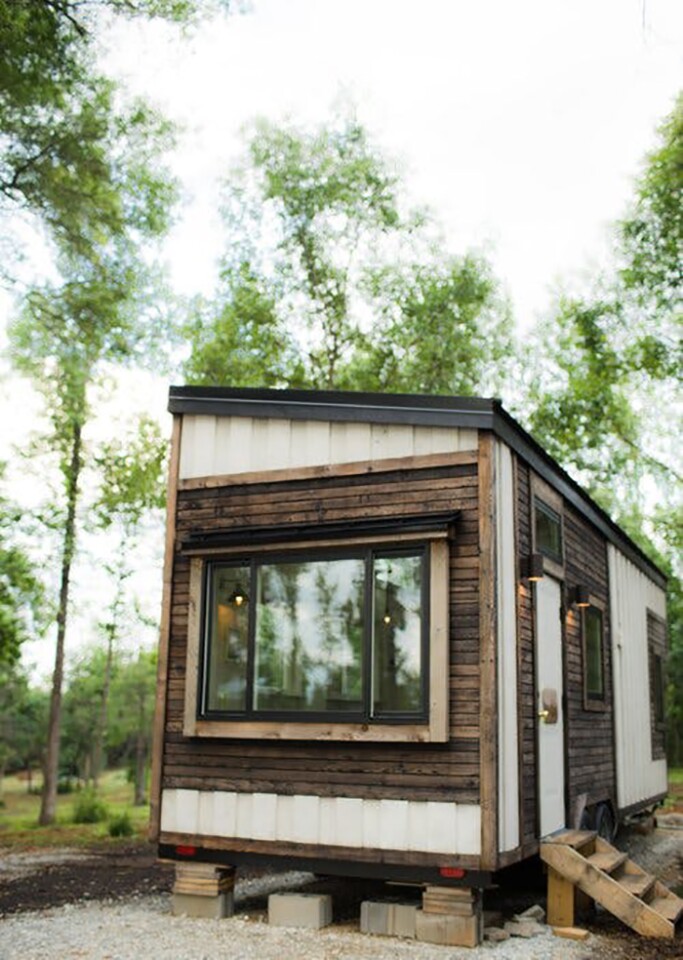 The exterior of the 26-ft-long Legacy tiny house is lined with cedar siding matched with contrasting Shou Sugi Ban-style charred cedar trim