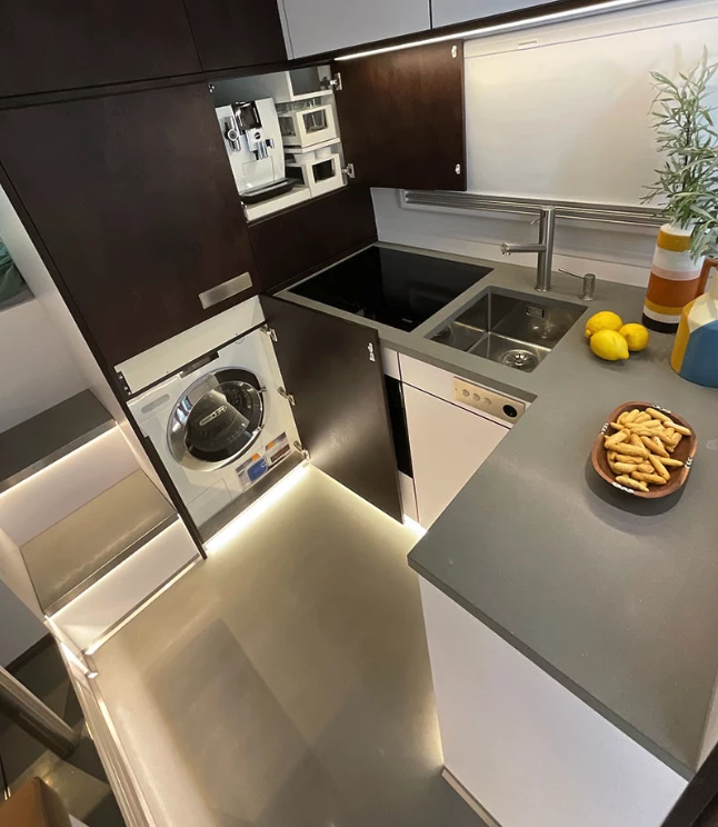The kitchen includes a four-place induction cooktop, washer/dryer, microwave and plenty of counter space