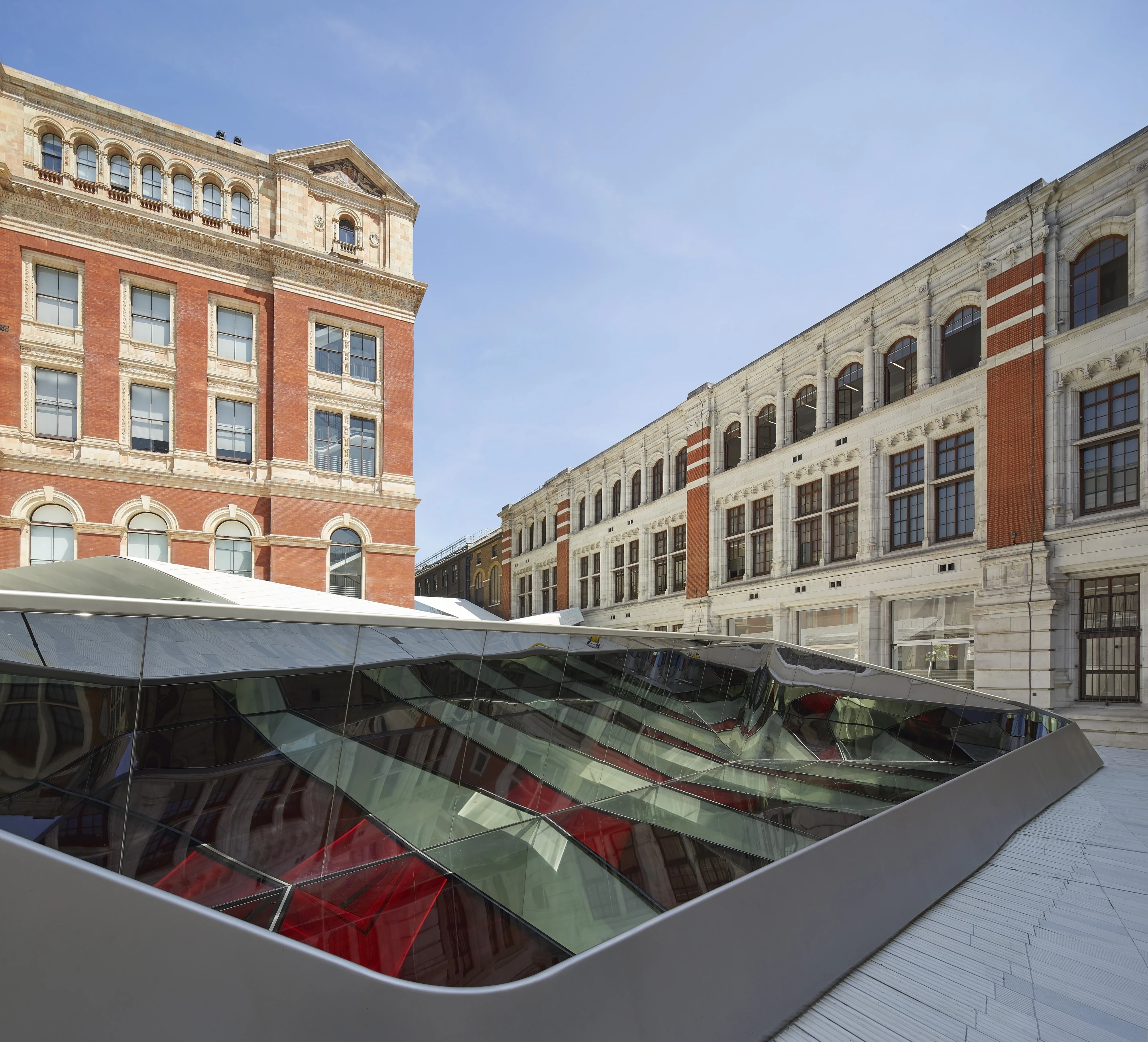 The folded plate structure supports the new courtyard and cafe on top, and is suspended over the gallery space inside