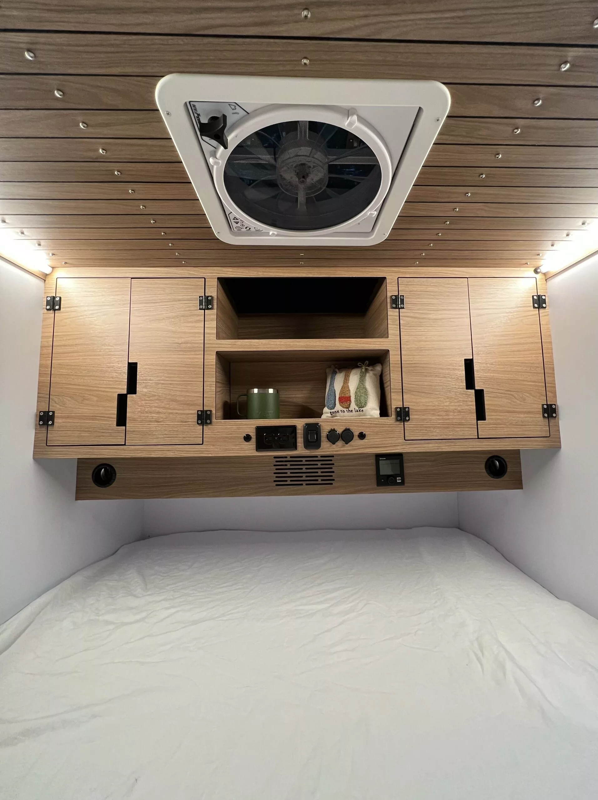 The Vega 2.0 comes with an RV queen bed, his and her cabinets, and central shelving