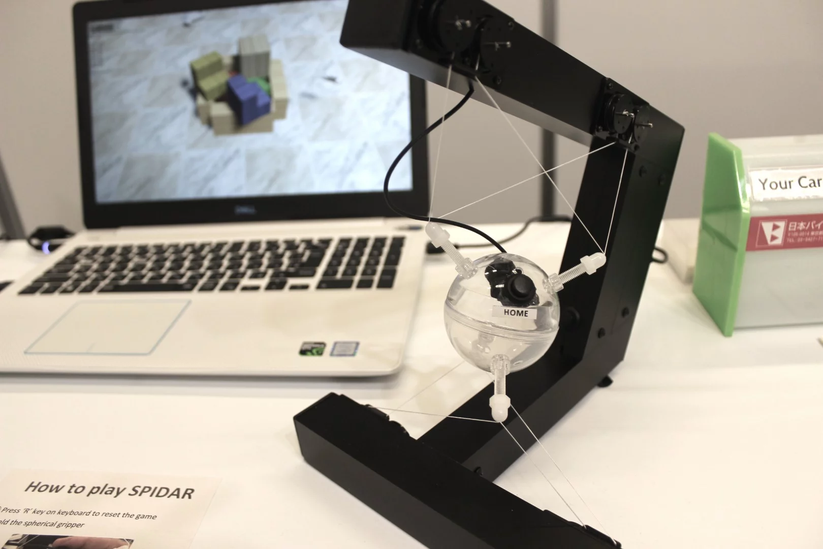 This is the Spidar-G II, from Japan's Nihon Binary – it's a haptic control device that utilizes wires, pulleys and DC motors to "read" the user's hand movements, allowing them to manipulate virtual objects or remotely operate robotic hands