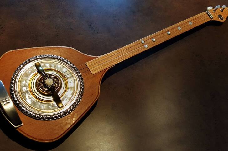 The Erin guitar has a main body of stacked and glued plywood layers with wood panels from an old desk used to cap the front and back