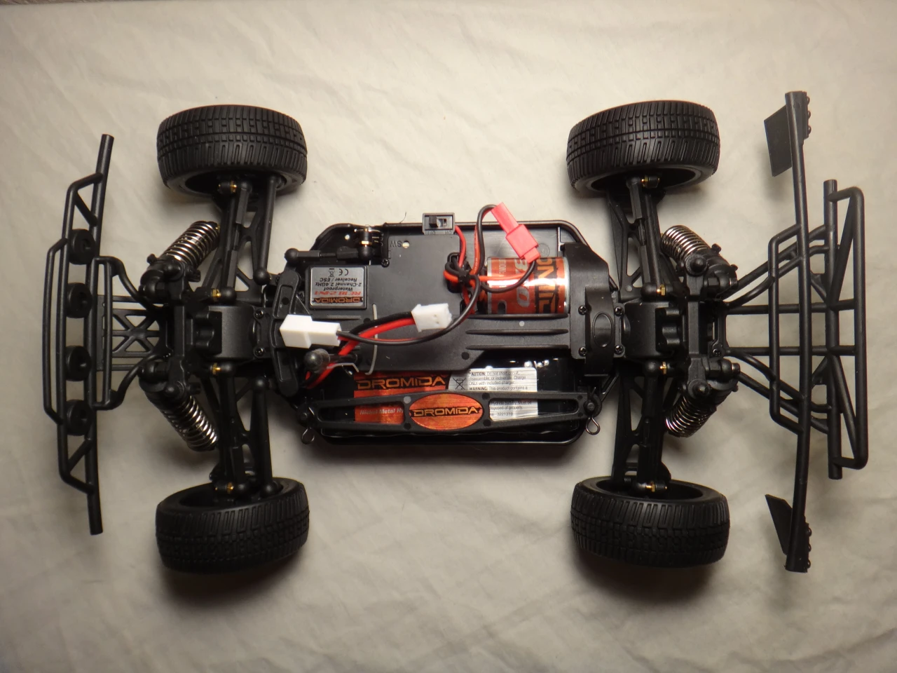 Each car includes a waterproof RE18 2-in-1 receiver/ESC, a DS100 steering servo, and an M370 motor, all of which bear the Dromida brand