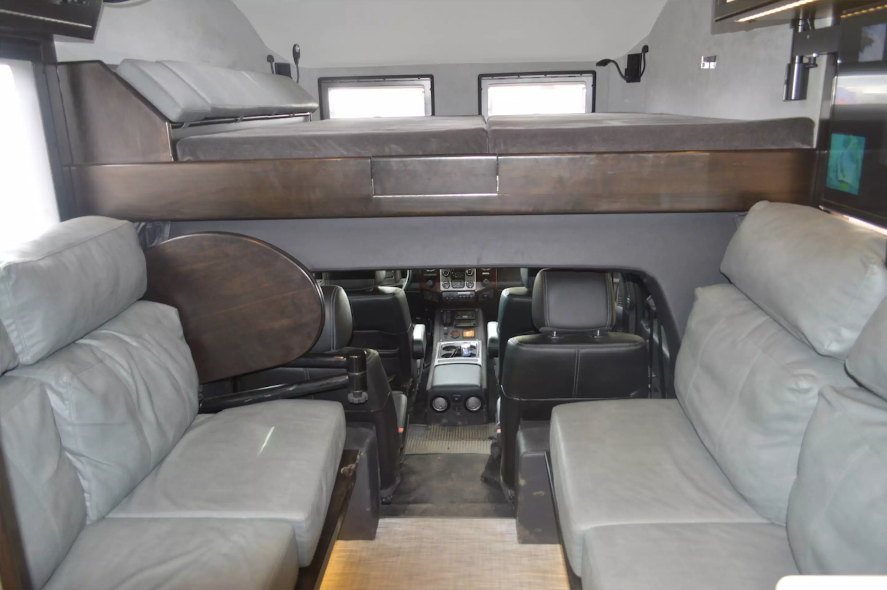 Electric-folding side couches and an upper bed provide sleeping space