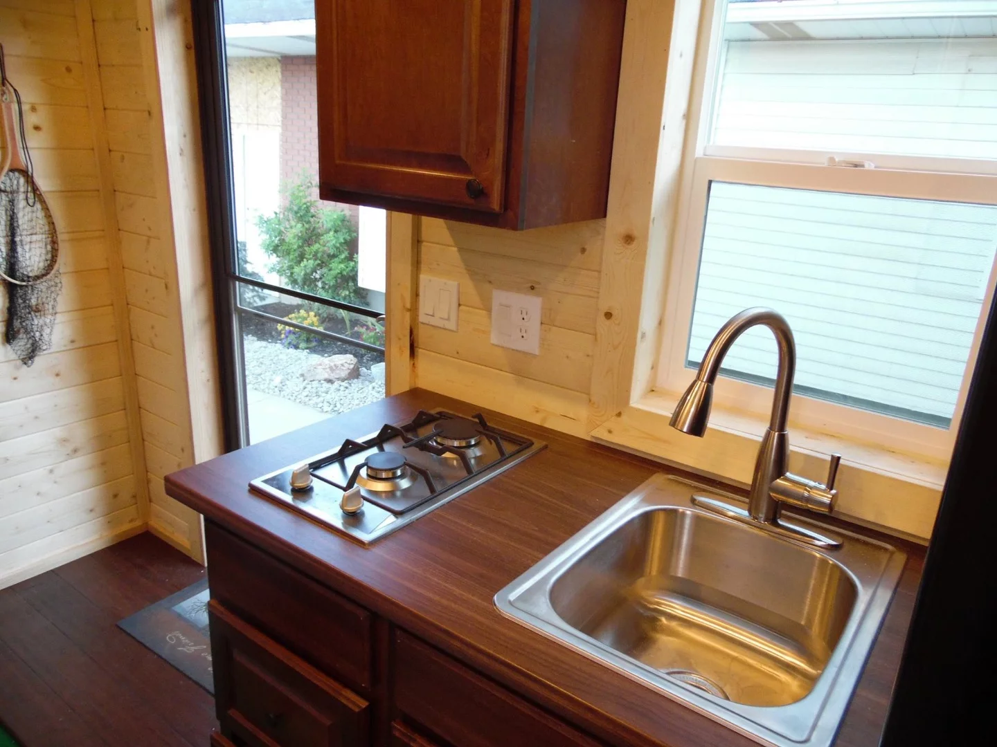 The kitchenette includes a propane double-burner and sink, storage space, and fridge/freezer