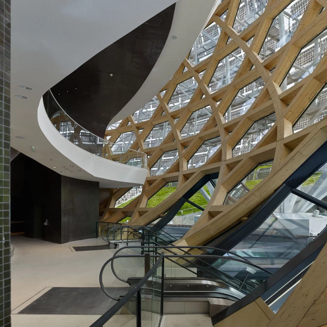 The glazed auditorium is supported by a shell of timber laminate made from woven spruce wood