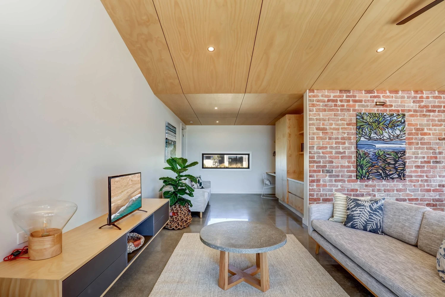 The home also features a series exposed brick walls, contrasting against the home's wooden panel ceilings and white finishes