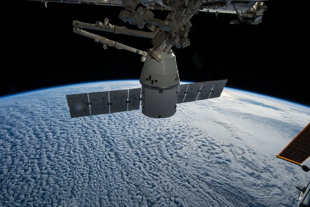 A robotic arm prepares Dragon for departure from the ISS