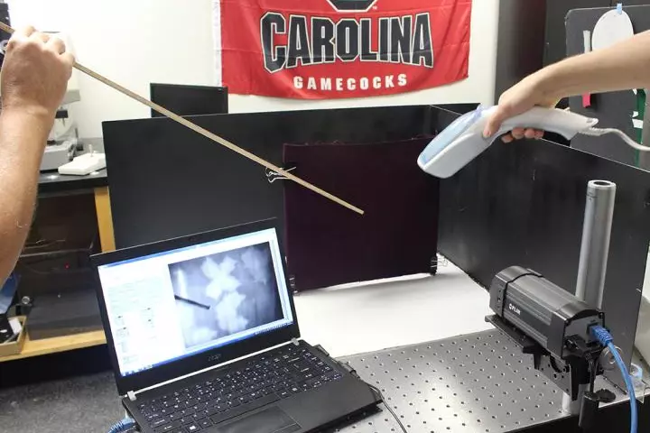 A hand steamer and an infrared camera are used to reveal blood markings on a black background