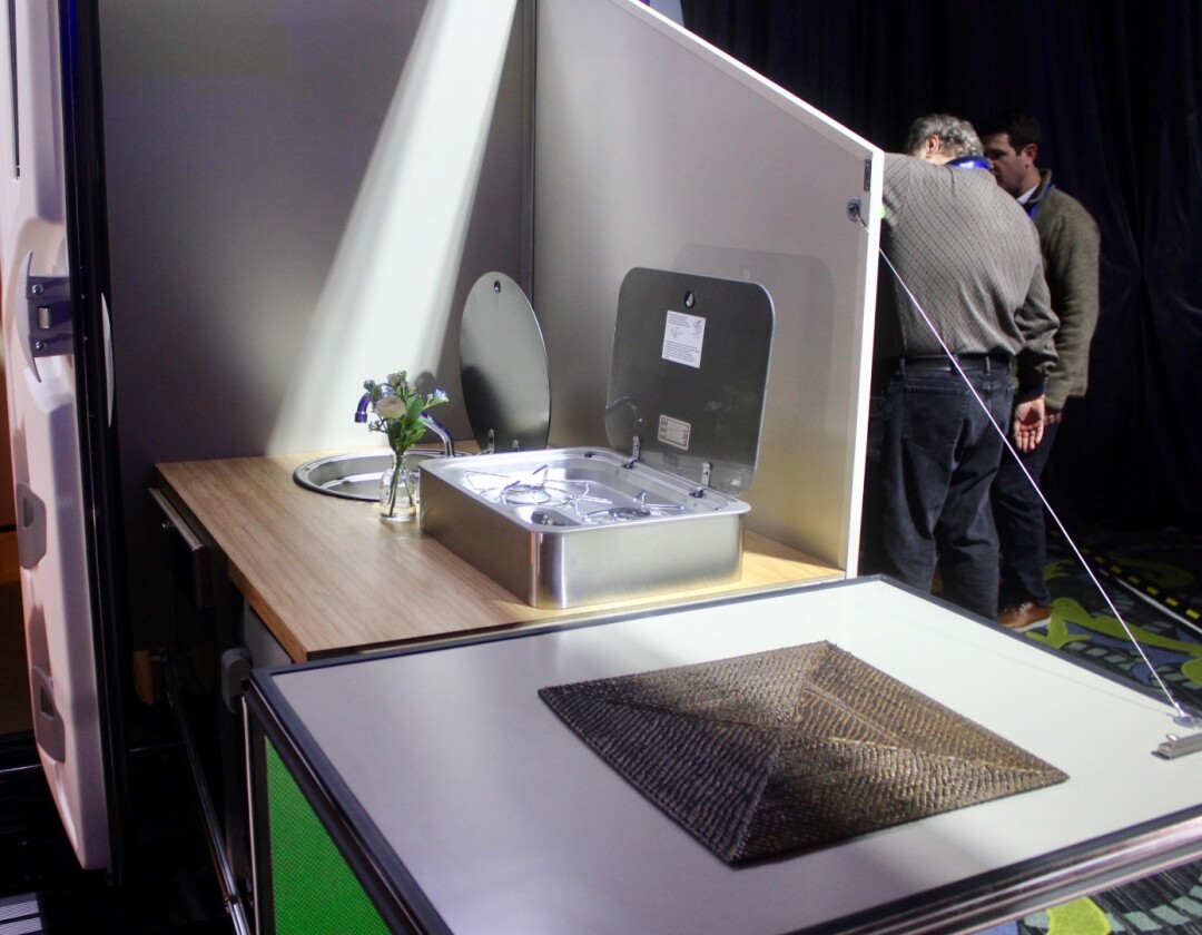 The kitchen, which can also be used inside, slides out and lowers to comfortable cooking height, providing outdoor cooking