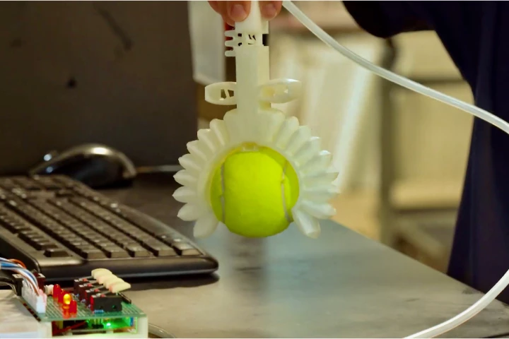 The gripper goes to work on a tennis ball