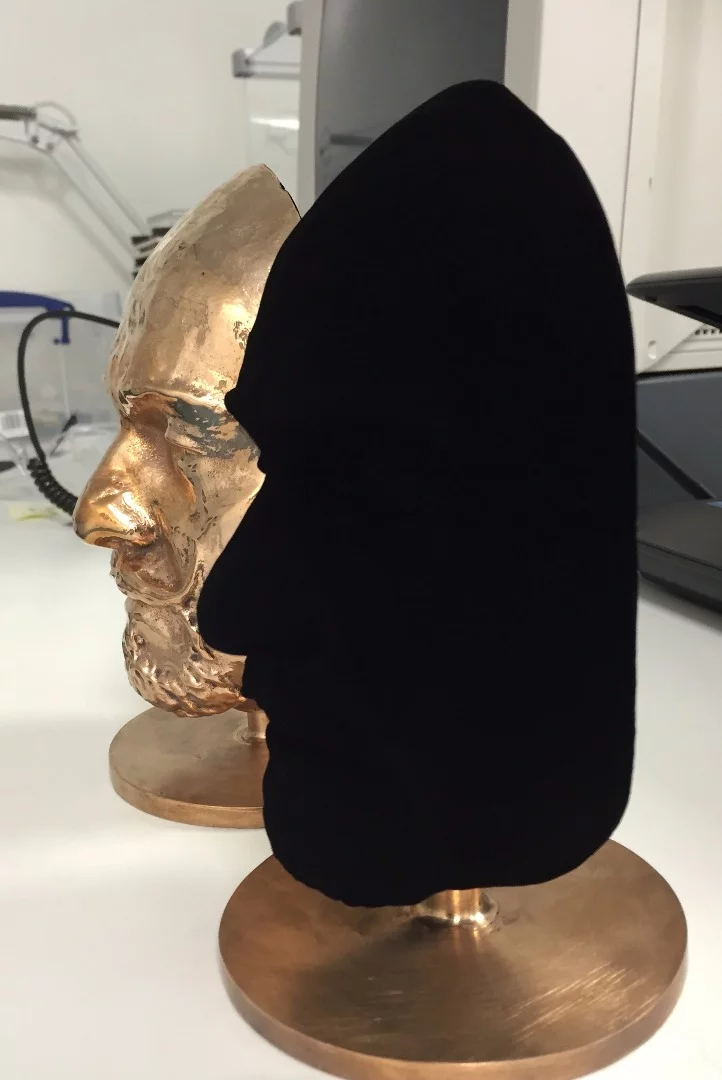 A three-dimensional face, coated in Vantablack S-VIS