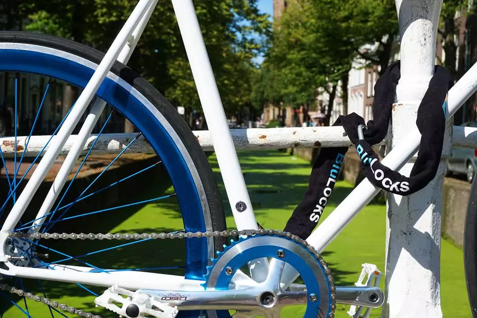 You start by looping the BluLock's nylon sleeve-covered hardened steel chain around an adjacent immovable object such as a sign post, then plugging a pin on the free end of that chain into a receptacle in the seat tube
