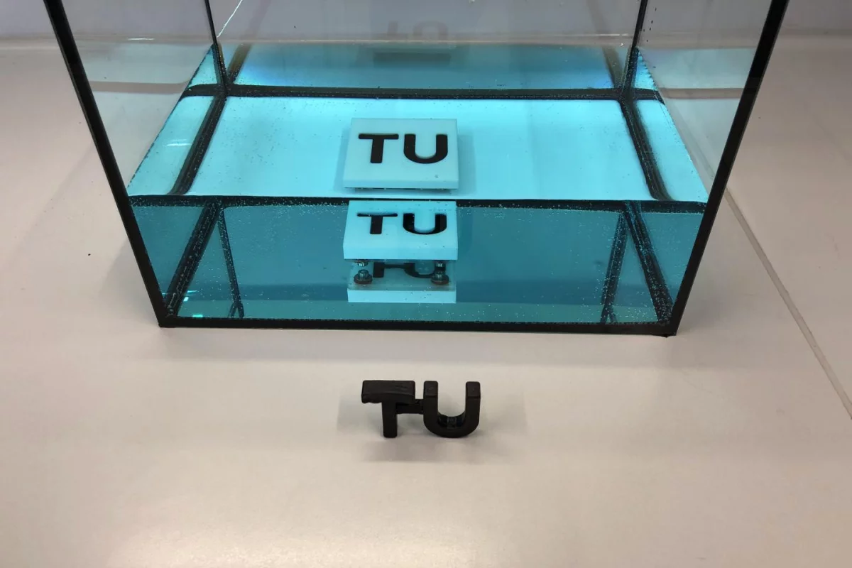 A sample of resin (black TU logo), that cured while submerged in a tank of water