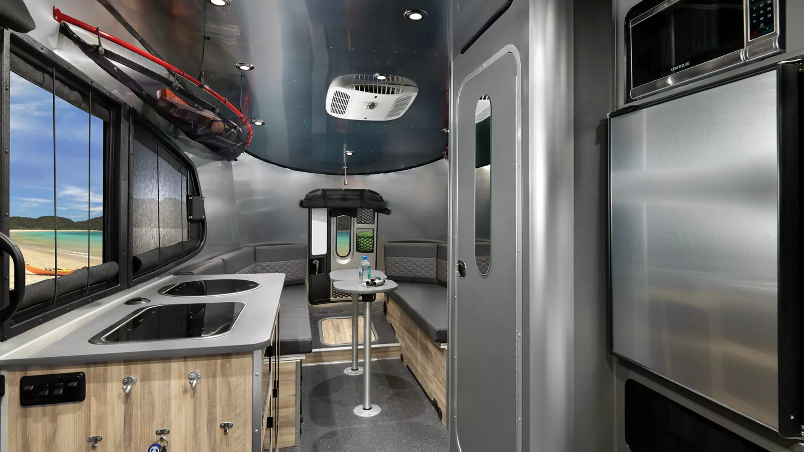 The Airstream 20 includes a central kitchen and wet bath and a rear dining lounge/convertible bed with two removable tables