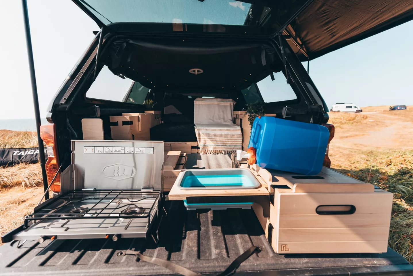 The stove pops out for use on the tailgate, and the sink sets up on the other side