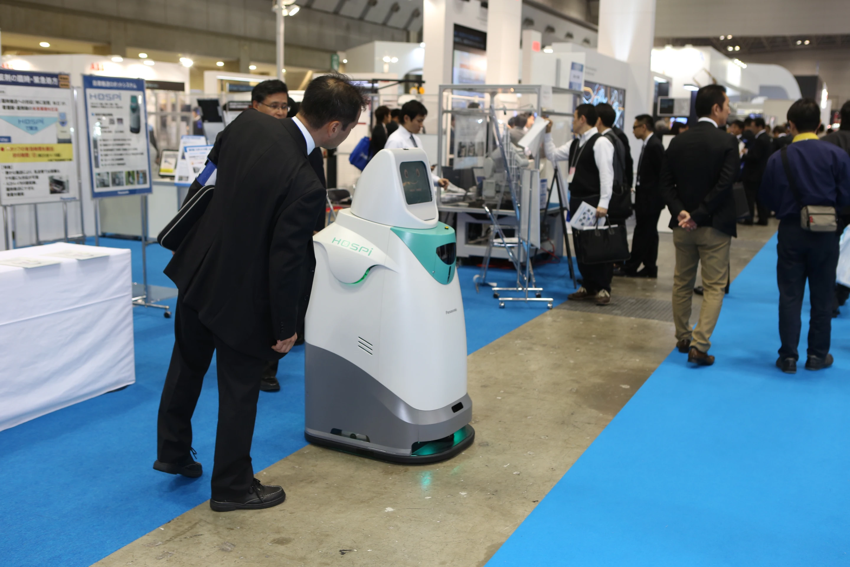 A curious onlooker checks out the HOSPI-R, Panasonic's hospital delivery robot, at IREX 2013 (Photo: Mike Hanlon, Gizmag)