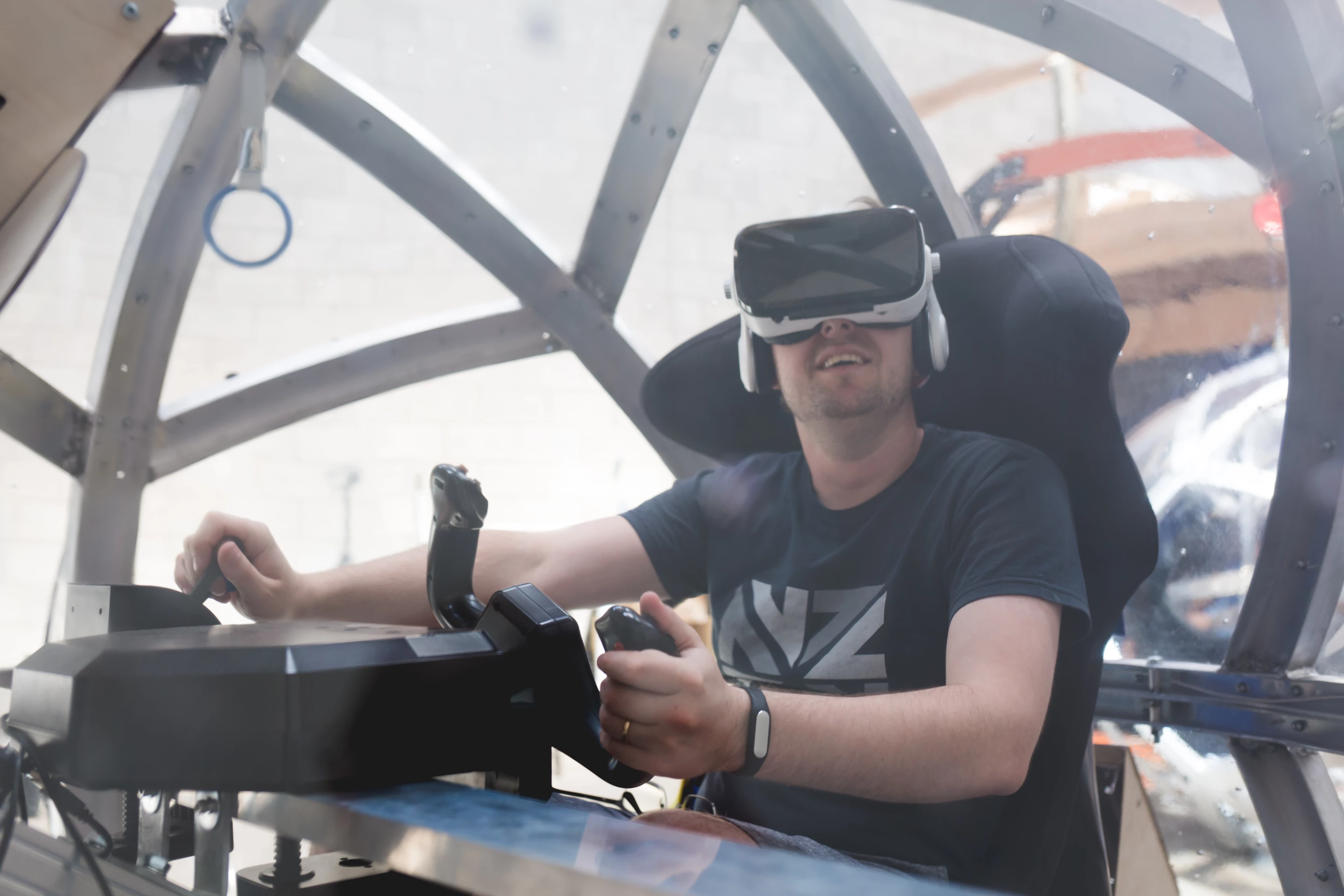 Users wear a VR headset and use physical controls