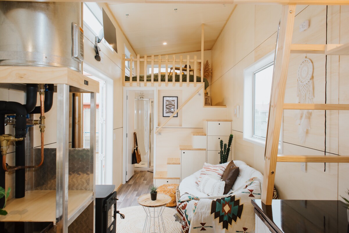 The Kahurangi Koinga Tiny House is centered around a small living area that contains a sofa and coffee table