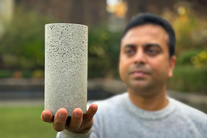 Dr. Chamila Gunasekara holds a sample of the low-carbon concrete