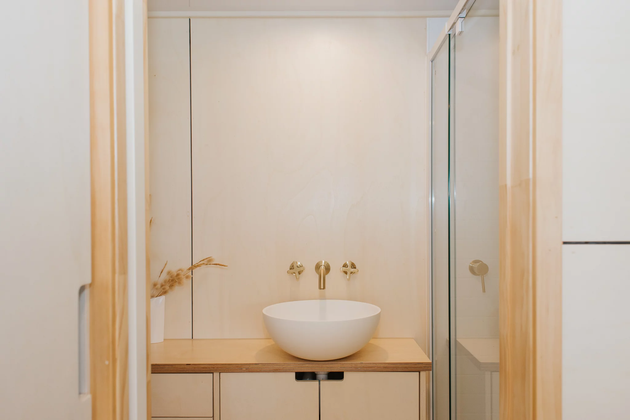 The Hilltop Tiny House's compact bathroom includes a sink, shower, and toilet