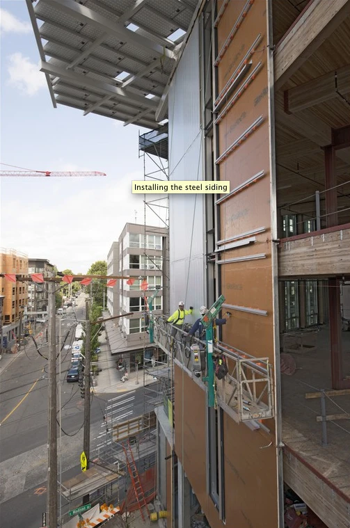 Steel sidings cover a liquid-applied air barrier