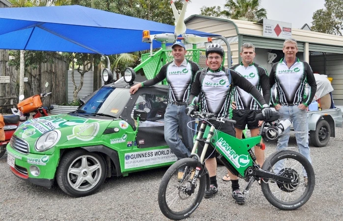 Allan Lear with his modified Stealth Bomber electric bike, and the ethanol-powered Mini Moke which charges the bike's batteries using rooftop-mounted wind turbines