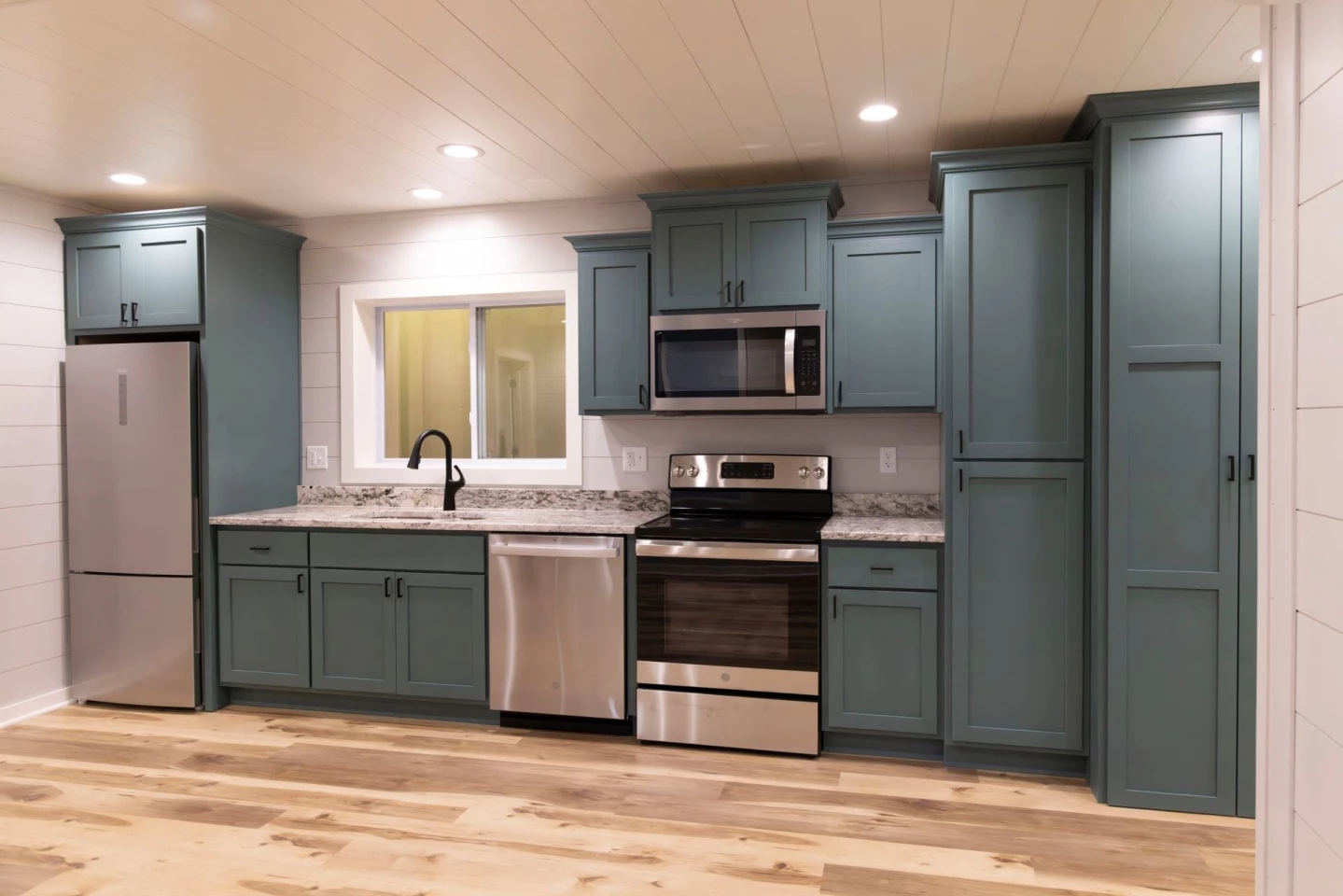 The Double Duo's kitchen is relatively spacious for a container-based house and includes a dishwasher, oven and microwave, and lots of cabinetry