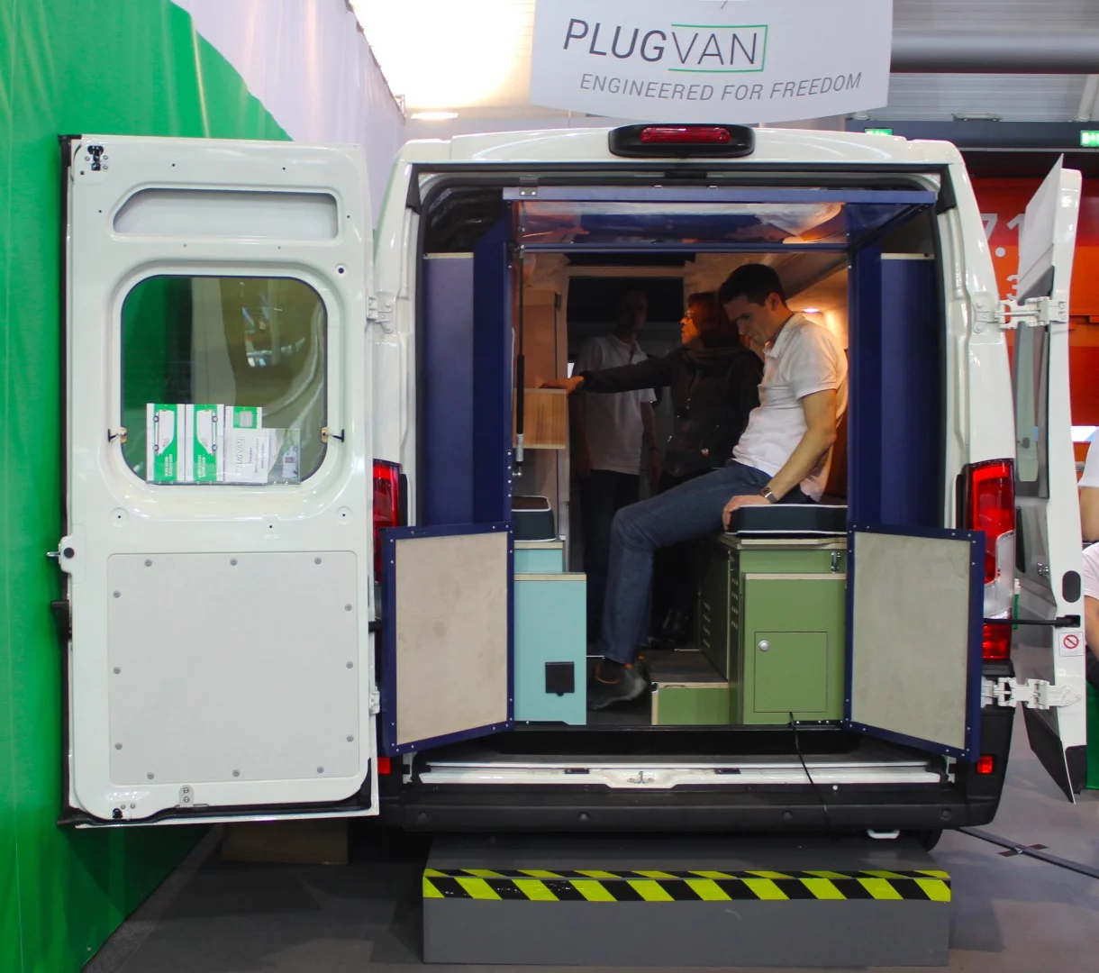 PlugVan founder Jörg Kortmann sits inside the PlugVan camper at CMT 2019