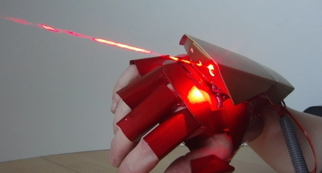 The glove features burning lasers on the top and in the palm